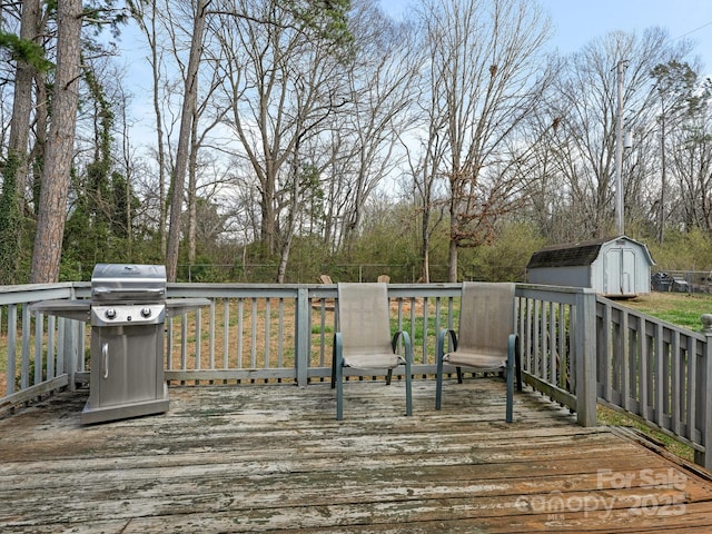 wooden terrace featuring an outbuilding, area for grilling, and a storage unit