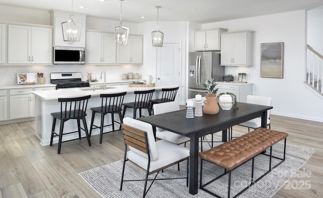 dining room with light wood-style flooring, recessed lighting, and baseboards