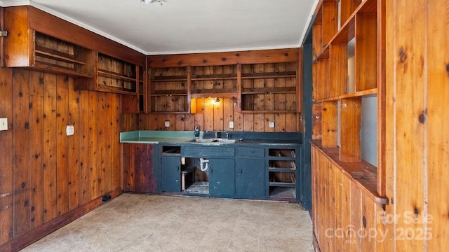 bar featuring a sink, wooden walls, and light floors