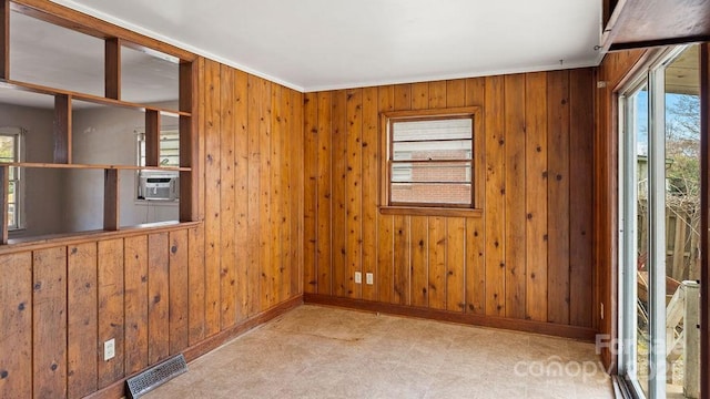 spare room featuring tile patterned floors, visible vents, plenty of natural light, and cooling unit