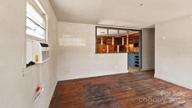 unfurnished room featuring hardwood / wood-style floors and baseboards