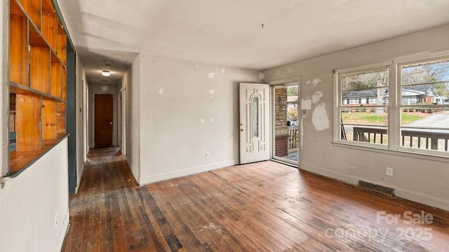 spare room with visible vents, wood-type flooring, and baseboards