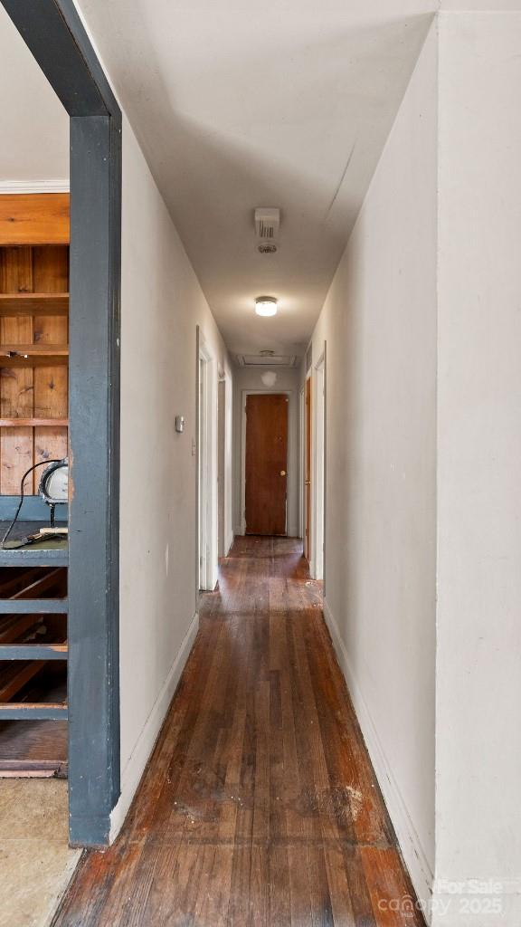 corridor with baseboards and hardwood / wood-style flooring