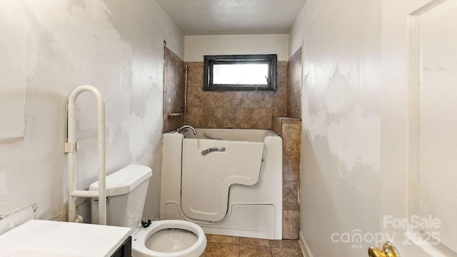 bathroom featuring a bath and toilet