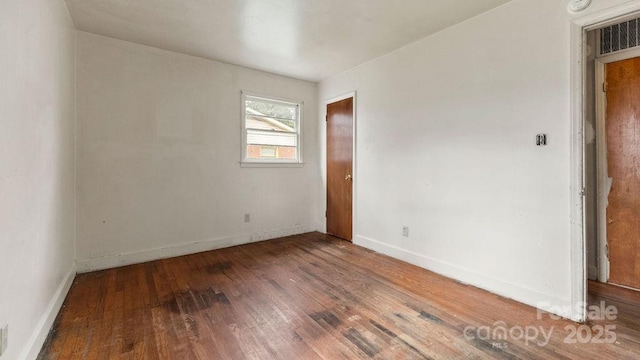 empty room featuring baseboards and wood finished floors