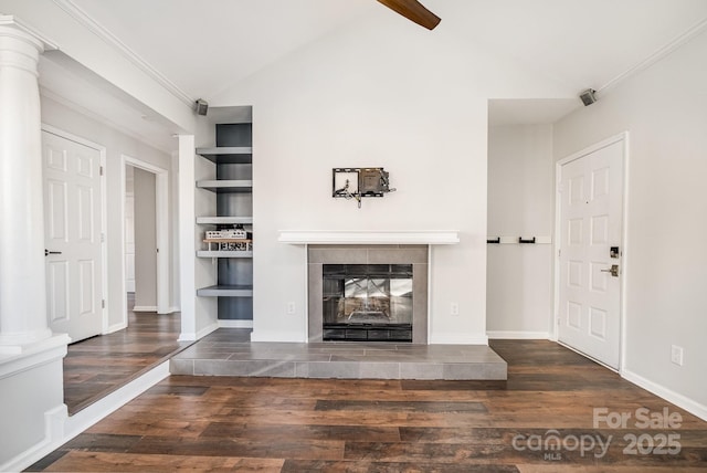 unfurnished living room featuring built in features, wood finished floors, a fireplace, baseboards, and vaulted ceiling