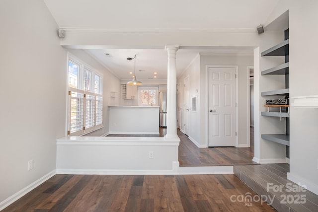 interior space with decorative columns, baseboards, dark wood-type flooring, and ornamental molding