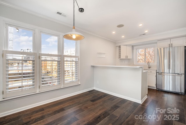 kitchen featuring visible vents, white cabinetry, and freestanding refrigerator