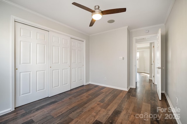 unfurnished bedroom with a closet, dark wood-style floors, and ornamental molding