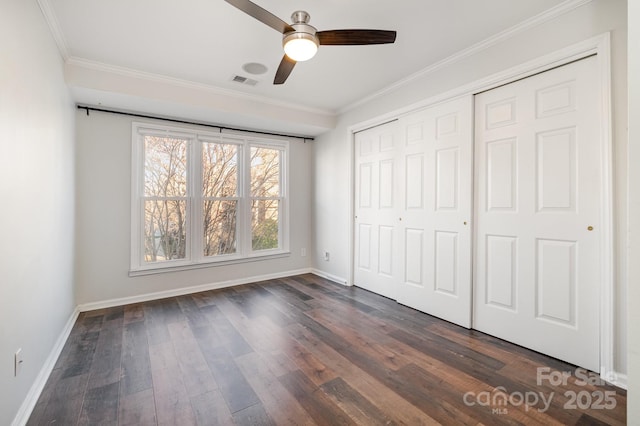 unfurnished bedroom featuring visible vents, crown molding, baseboards, and dark wood-style flooring