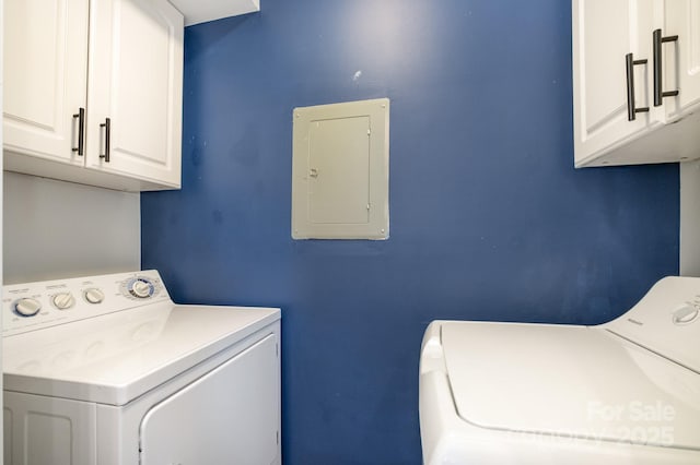 clothes washing area with washer and dryer, electric panel, and cabinet space