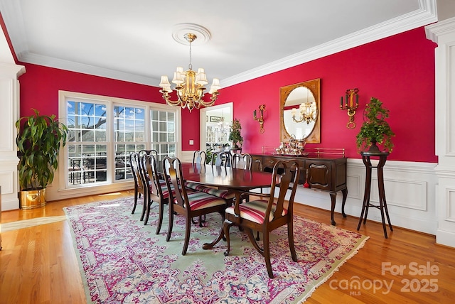 dining room featuring an inviting chandelier, wood finished floors, and ornamental molding