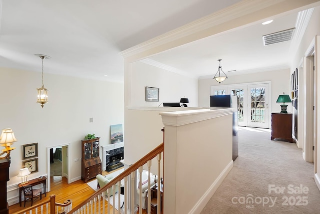 corridor featuring crown molding, an upstairs landing, visible vents, and baseboards