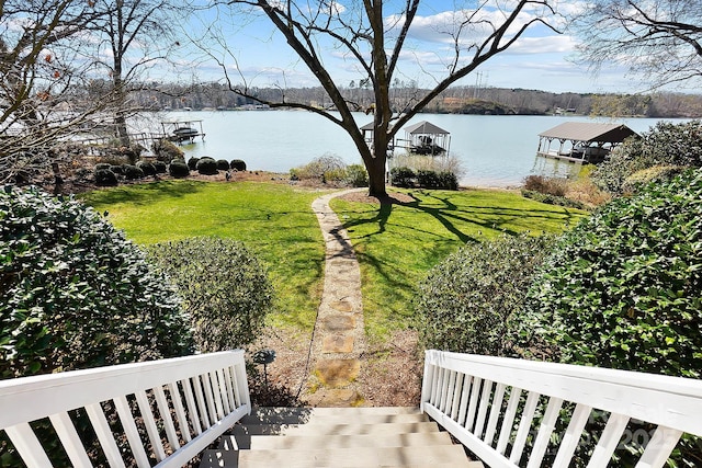 view of yard with a water view and a dock