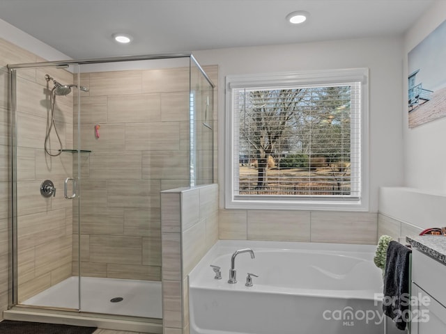 full bathroom with a shower stall, a bath, and recessed lighting