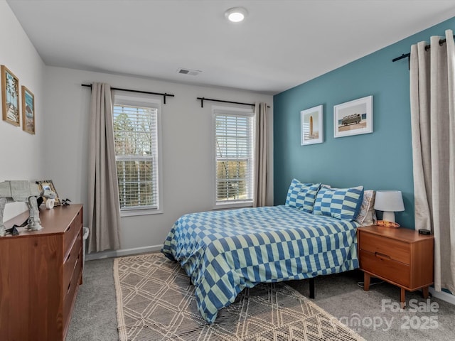 carpeted bedroom featuring visible vents and baseboards