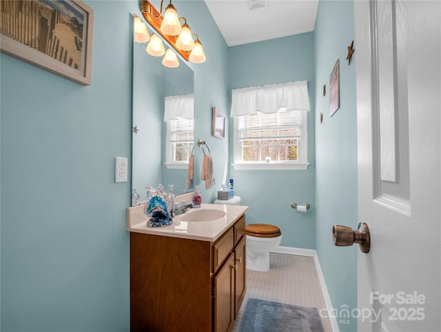 bathroom featuring tile patterned floors, baseboards, toilet, and vanity