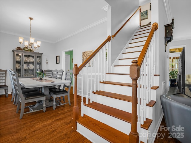 dining room featuring a notable chandelier, crown molding, stairs, and wood finished floors
