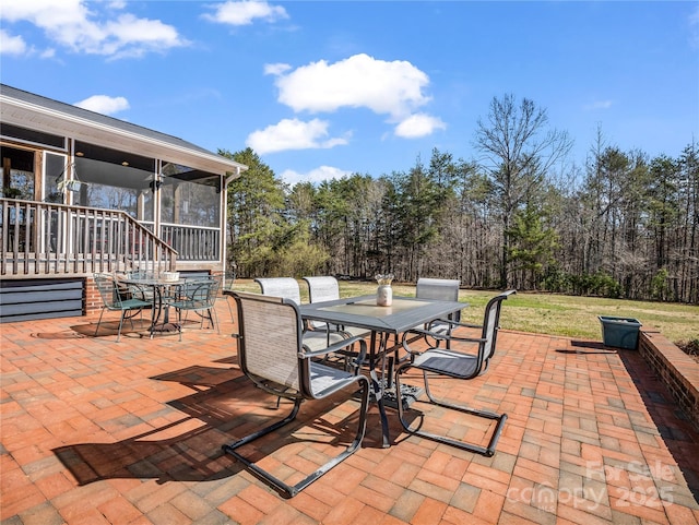 view of patio / terrace with outdoor dining area and a sunroom