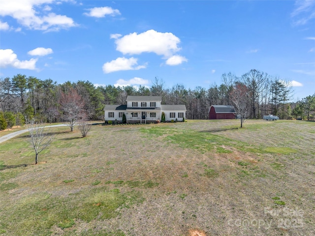 view of front of house with an outdoor structure, a front yard, and driveway