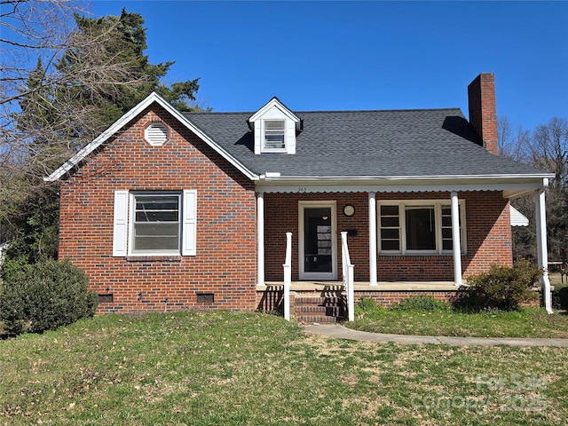 view of front facade featuring a porch, a shingled roof, a front lawn, crawl space, and brick siding