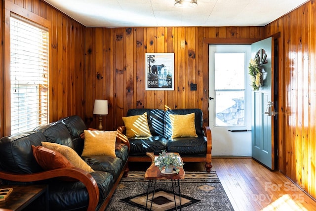 living area featuring wooden walls and hardwood / wood-style flooring