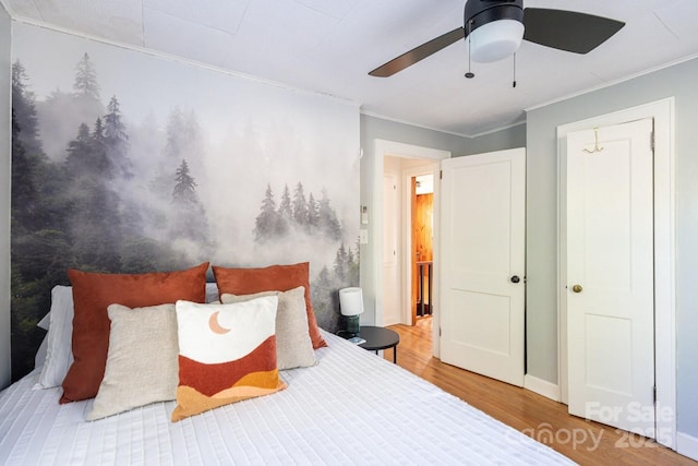 bedroom featuring ornamental molding, baseboards, ceiling fan, and wood finished floors