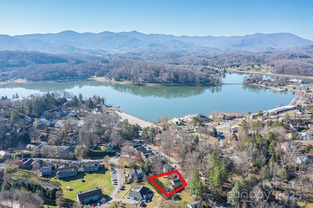 aerial view with a water and mountain view and a wooded view