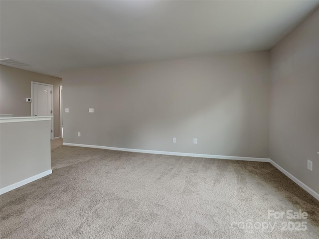 spare room with baseboards and carpet floors