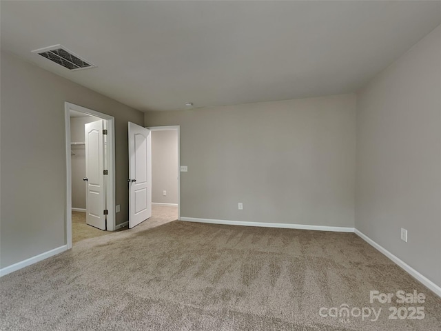 unfurnished room featuring carpet, visible vents, and baseboards