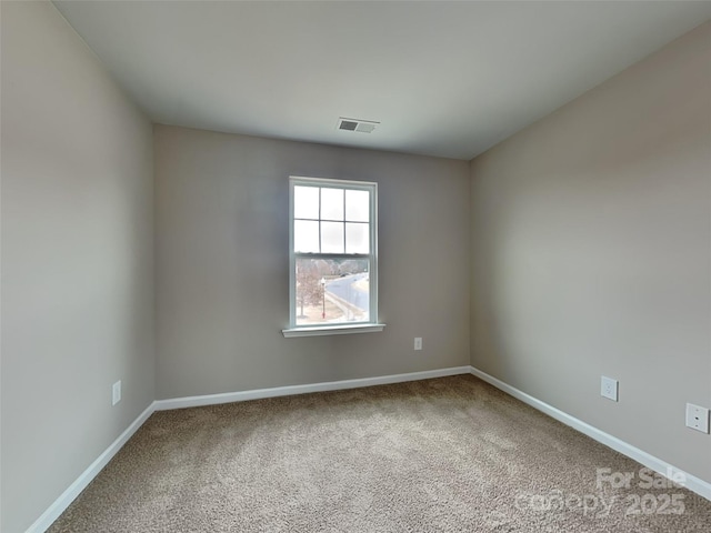 unfurnished room with visible vents, baseboards, and carpet