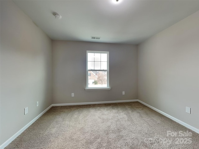 carpeted empty room featuring visible vents and baseboards