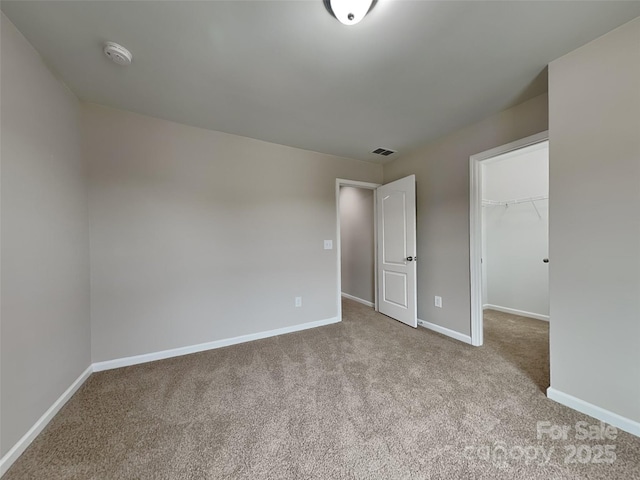 carpeted spare room with visible vents and baseboards