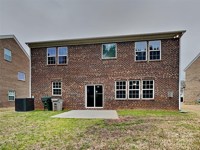 back of house with a patio, central air condition unit, a lawn, and brick siding