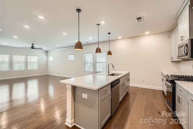 kitchen featuring visible vents, dark wood-type flooring, a sink, appliances with stainless steel finishes, and ceiling fan