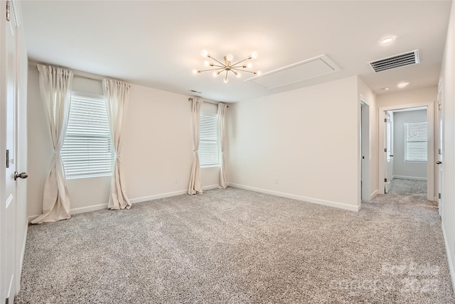 unfurnished room with a wealth of natural light, visible vents, carpet flooring, baseboards, and attic access