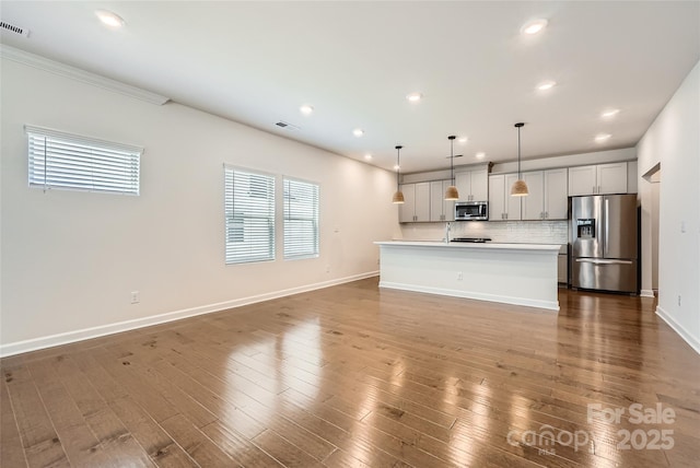 kitchen featuring dark wood-style floors, visible vents, light countertops, appliances with stainless steel finishes, and tasteful backsplash