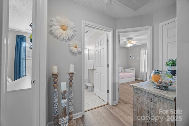 bathroom featuring visible vents, baseboards, a textured ceiling, and wood finished floors