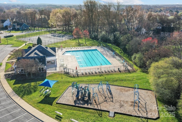 view of swimming pool with a yard and fence