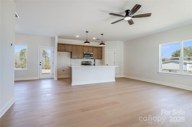 kitchen featuring a wealth of natural light, light wood-style flooring, appliances with stainless steel finishes, and open floor plan