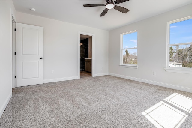 unfurnished bedroom featuring a ceiling fan, ensuite bathroom, baseboards, and carpet floors