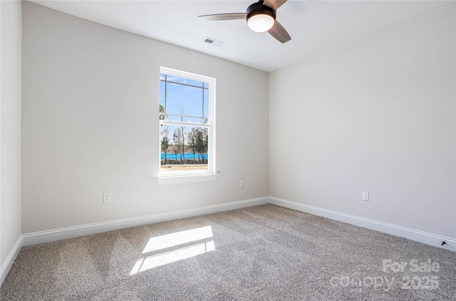 carpeted empty room with a ceiling fan, baseboards, and visible vents