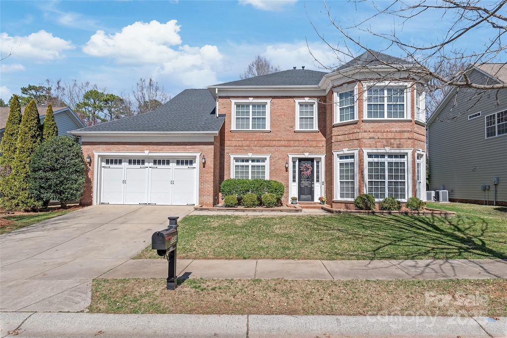 view of front of home featuring brick siding, a front yard, roof with shingles, driveway, and an attached garage