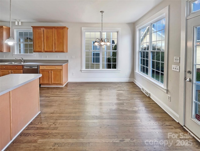 kitchen with visible vents, dark wood-type flooring, pendant lighting, brown cabinets, and a chandelier