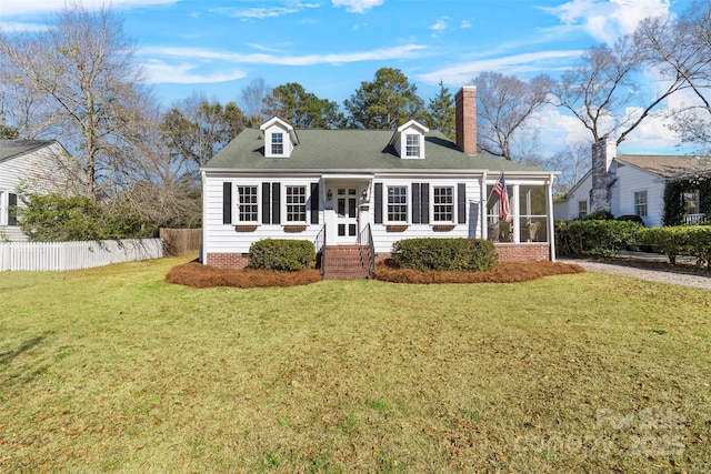 cape cod-style house featuring a front lawn, fence, a sunroom, and a chimney