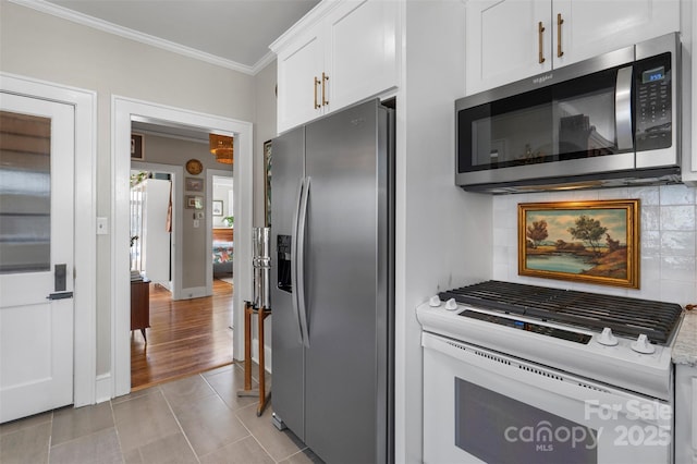 kitchen with light countertops, appliances with stainless steel finishes, white cabinetry, crown molding, and tasteful backsplash