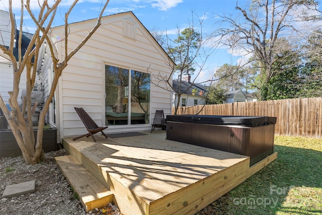 wooden terrace with a hot tub and fence