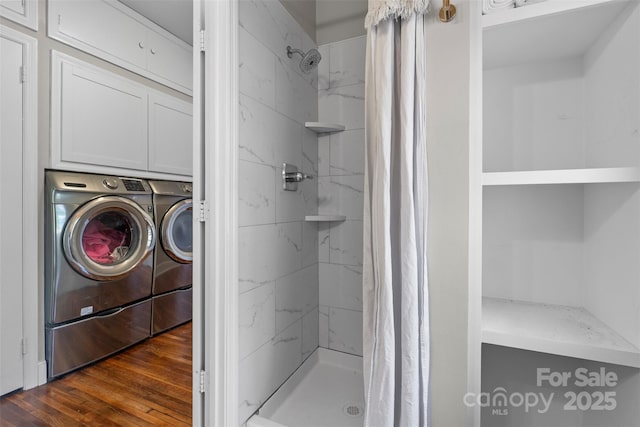 full bath featuring a shower stall, wood finished floors, and washing machine and dryer