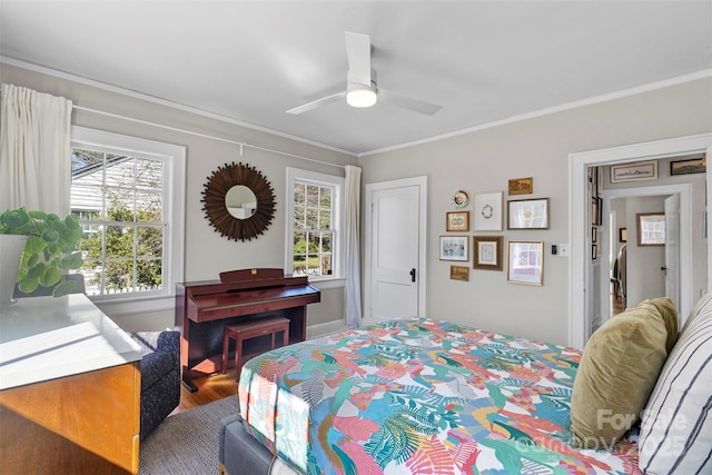 bedroom featuring multiple windows, crown molding, a ceiling fan, and wood finished floors