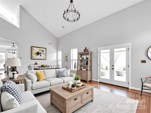 6200 Summertree Ln, Charlotte, NC 28226 - living area with a chandelier, high vaulted ceiling, light wood finished floors, french doors, and baseboards